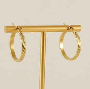 Detailed view of 18K gold plated hoop earrings with elegant twisted texture on T-stand