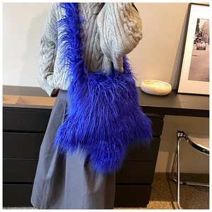Detail shot of a stylish blue faux fur shoulder bag worn by a model in a casual setting