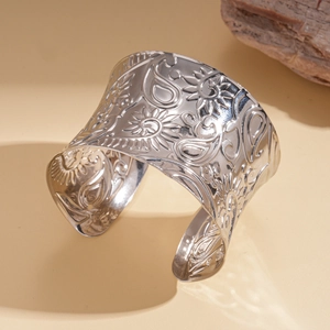 Western style wide open metal cuff bracelet with silver paisley pattern and sun flower relief