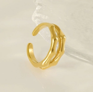 Detaillierte Nahaufnahme eines doppelstöckigen Goldrings im Bambus-Design auf Textur