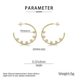 Close-up of golden stainless steel C-shaped earrings with white zircon inlay and 37x2mm specs
