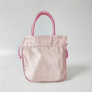 Detailed view of pink satin drawstring handbag with smooth texture and arc handle