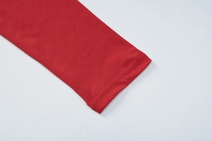 Close-up of sleeve cuffs with double-needle stitching on red long sleeve V-neck dress