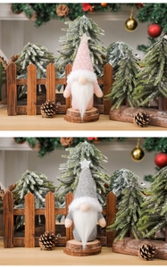 Detailed view of Christmas gnomes with knit hats and stars on rustic wooden bases
