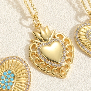 Detailed close-up of gold heart pendant with zircons and vintage crown decor