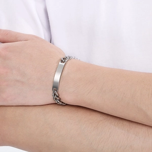 Detail of custom engraved curved bar on silver stainless steel Cuban chain bracelet