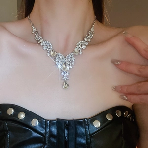 Close-up of model wearing silver teardrop crystal necklace in luxury vintage style