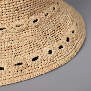 Détail du chapeau de soleil en raphia tressé main avec motifs ajourés et textures
