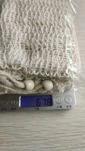 Detailed view of a natural jute soap bag on an electronic scale weighing 67.8g