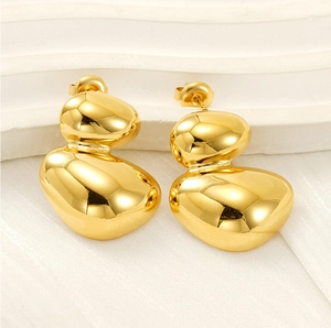 Vue détaillée de boucles d'oreilles dorées irrégulières avec une finition miroir polie
