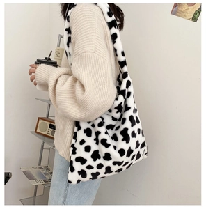 Close-up of fluffy black and white cow print plush tote bag with large capacity