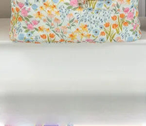 Detailed close-up of quilted floral fabric with intricate diamond stitching and colorful patterns