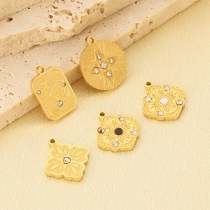 Close-up of five French vintage gold stainless steel pendants with rhinestones and enamel