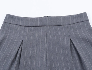 Gros plan sur la texture rayée grise et les détails plissés de la taille du short