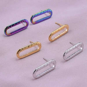 Close-up of geometric oval stud earrings in rainbow, gold, and silver stainless steel