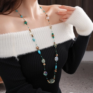 Close-up of bohemian layered necklace with turquoise beads and golden butterfly charm