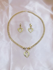 Golden heart wing jewelry set with necklace and earrings on pink satin fabric