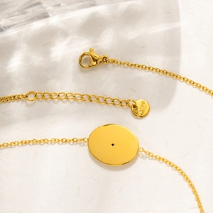 Detail of 18K gold plated stainless steel bracelet with lobster clasp and oval pendant