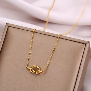 Minimalist golden love knot pendant necklace displayed on a premium gift box background