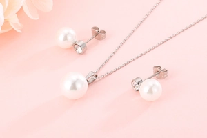 Detail of shell pearl jewelry set featuring silver necklace and matching stud earrings