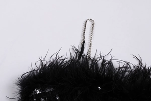 Détail de plumes noires avec tissu à paillettes et fines bretelles en strass