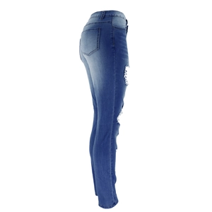 Detailed view of high waist distressed jeans with side ripped details and slim fit denim