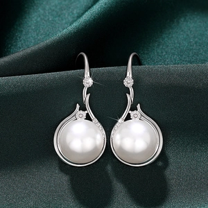 Detailed view of elegant faux pearl earrings with sparkling diamond-set silver accents