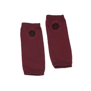 Detail of dark red knit arm warmers with ribbed cuffs and functional thumb hole design