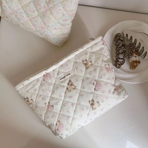 Detailed view of quilted cotton makeup bag with floral dog print and brand label