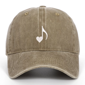 Detailed close-up of music heart embroidery on khaki washed cotton baseball cap