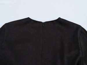 Détail d'une robe noire en sergé avec fermeture éclair invisible et encolure ronde classique