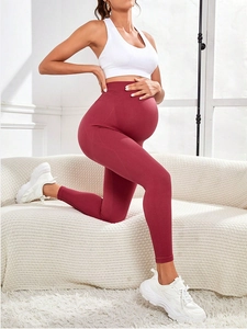 Detail of high waisted seamless maternity yoga pants in deep red with soft fabric texture