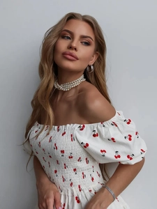 Detail of white square neck dress with red cherry print and pleated texture fabric