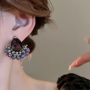 Detail of purple teardrop zirconia stud earrings with gold plating on model side view