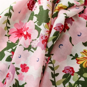 Detailed close-up of soft floral print fabric with pink flowers and green leaves