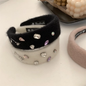 Detail of plush rhinestone rose headbands in black, white, and pink with handmade labels