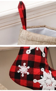 Detail of buffalo plaid Christmas stocking with 3D snowflake embroidery and linen cuff