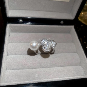 Vue détaillée d'une bague ouverte fleur et perle dans un écrin à bijoux de luxe en velours