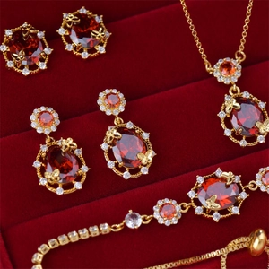 Detailed view of 18K gold plated jewelry set with red gemstones in a red velvet box