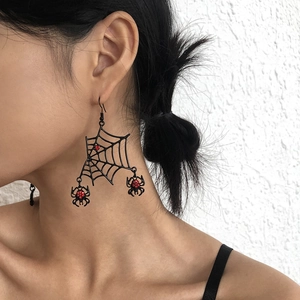 Detail of gothic spider web earrings with red crystals worn by a female model