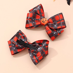 Detail of Halloween hair clips featuring red plaid bows with pumpkin and ghost motifs