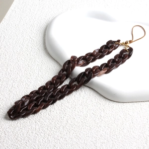 Detail of brown acrylic chain phone strap with gold metal clasp on white display