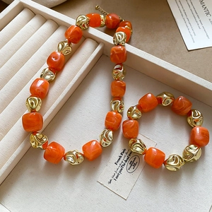 Detail of orange marble resin and gold irregular metal beads in jewelry box set