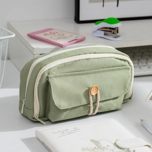 Macro view of multi-layer pale green canvas pencil case with wood button and rope detail