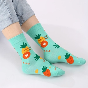 Mint green cotton mid-calf socks with orange pineapple patterns and geometric elements