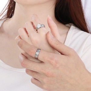 Close-up of 18K gold plated silver couples rings featuring a solitaire zircon and wave texture