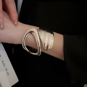 Detailed shot of an irregular geometric open cuff bracelet in a silver mirror finish