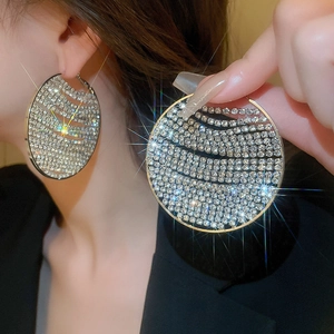 Detailed view of large gold hoop earrings with multi-layer sparkling rhinestones