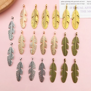 Detailed view of feather shape alloy charms in four metal finishes for DIY jewelry making