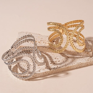 Minimalist geometric twisted open cuff bracelets in gold and silver finishes